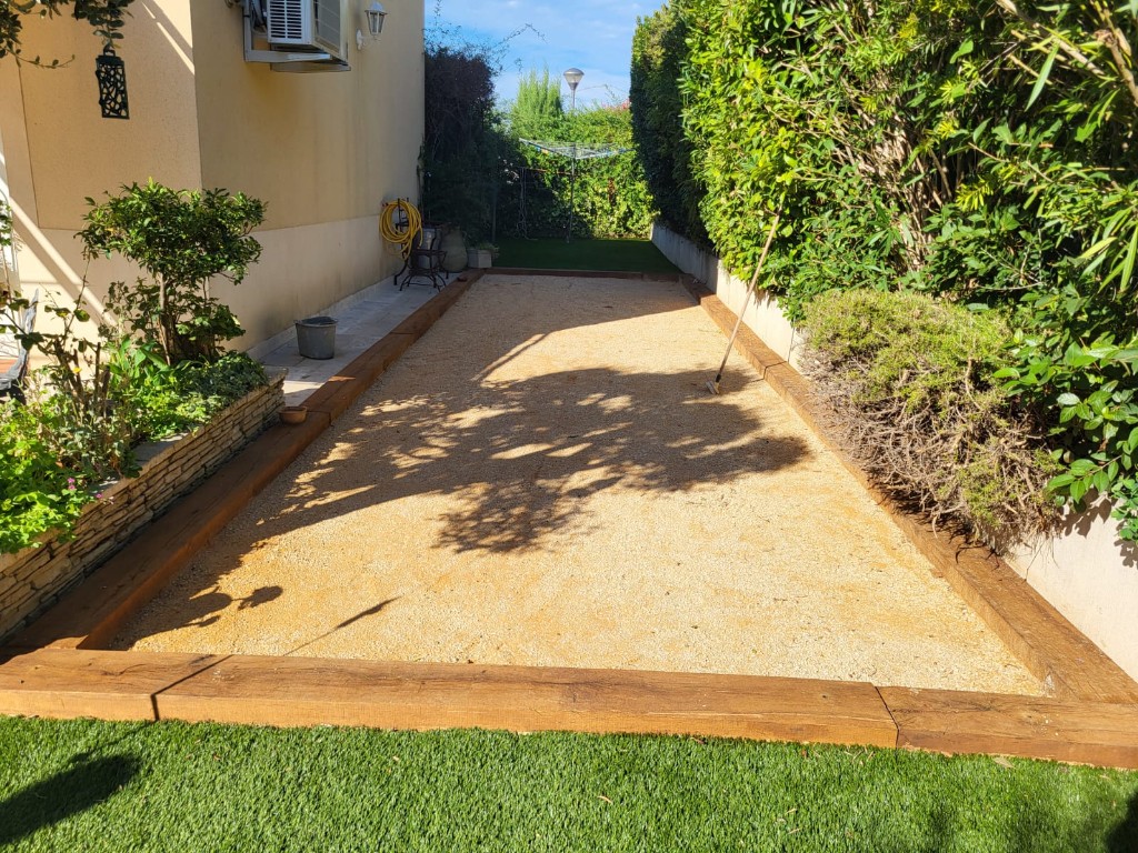 Terrain de pétanque pour particuliers dans un jardin avec haies